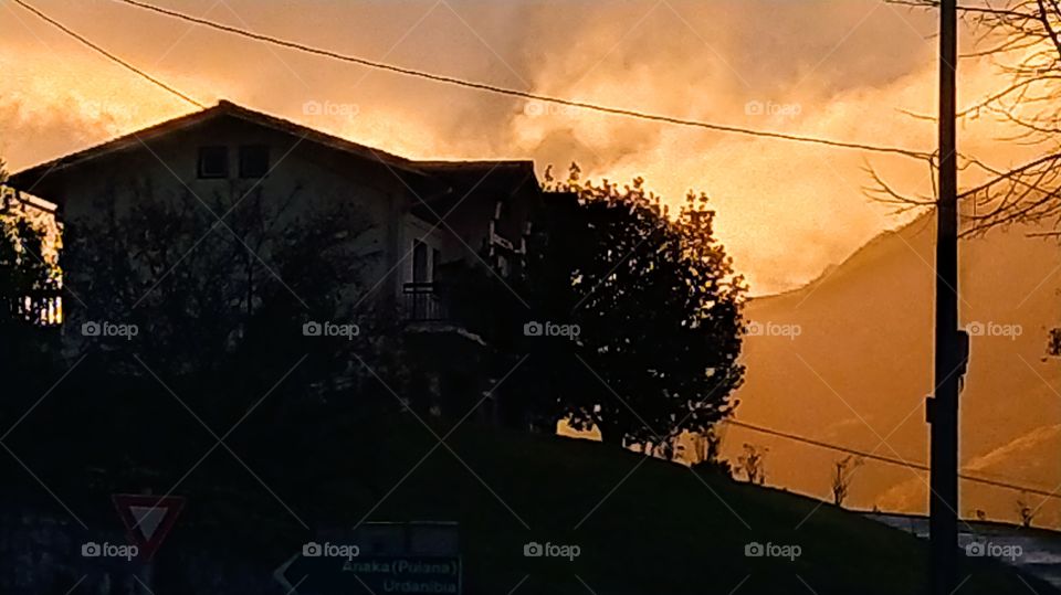 Sobre el fondo de un caserío, se deslumbra  un bello atardecer otoñal