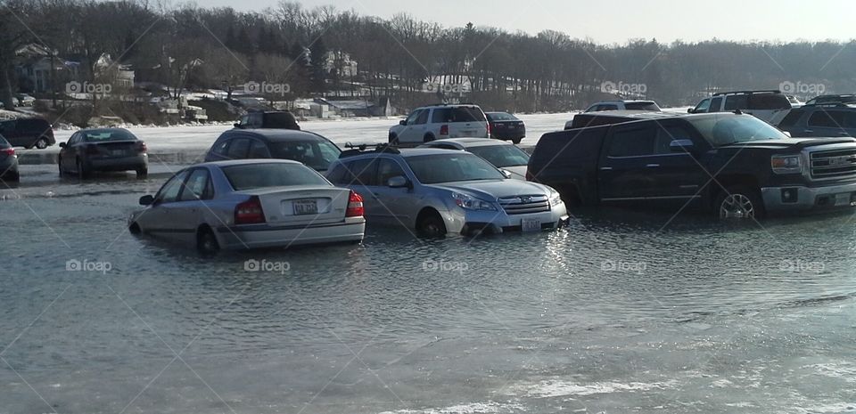 Agony in Slow Motion. Cars parked on Lake Geneva, WI for Winterfest slowly sank into the water as temperatures rapidly rose by the afternoon.