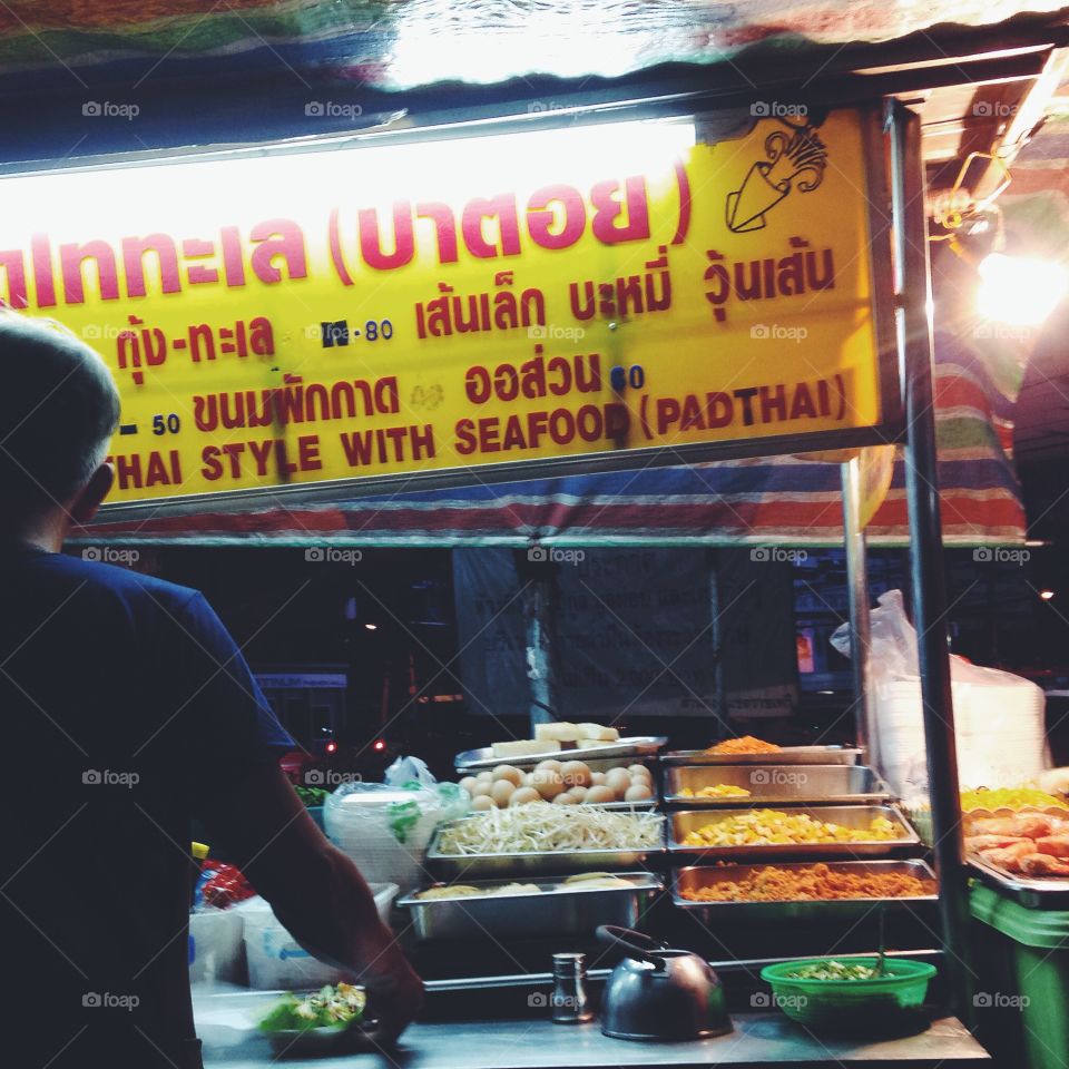 A street food stall owner prepares pad thai in Bangkok, Thailand.