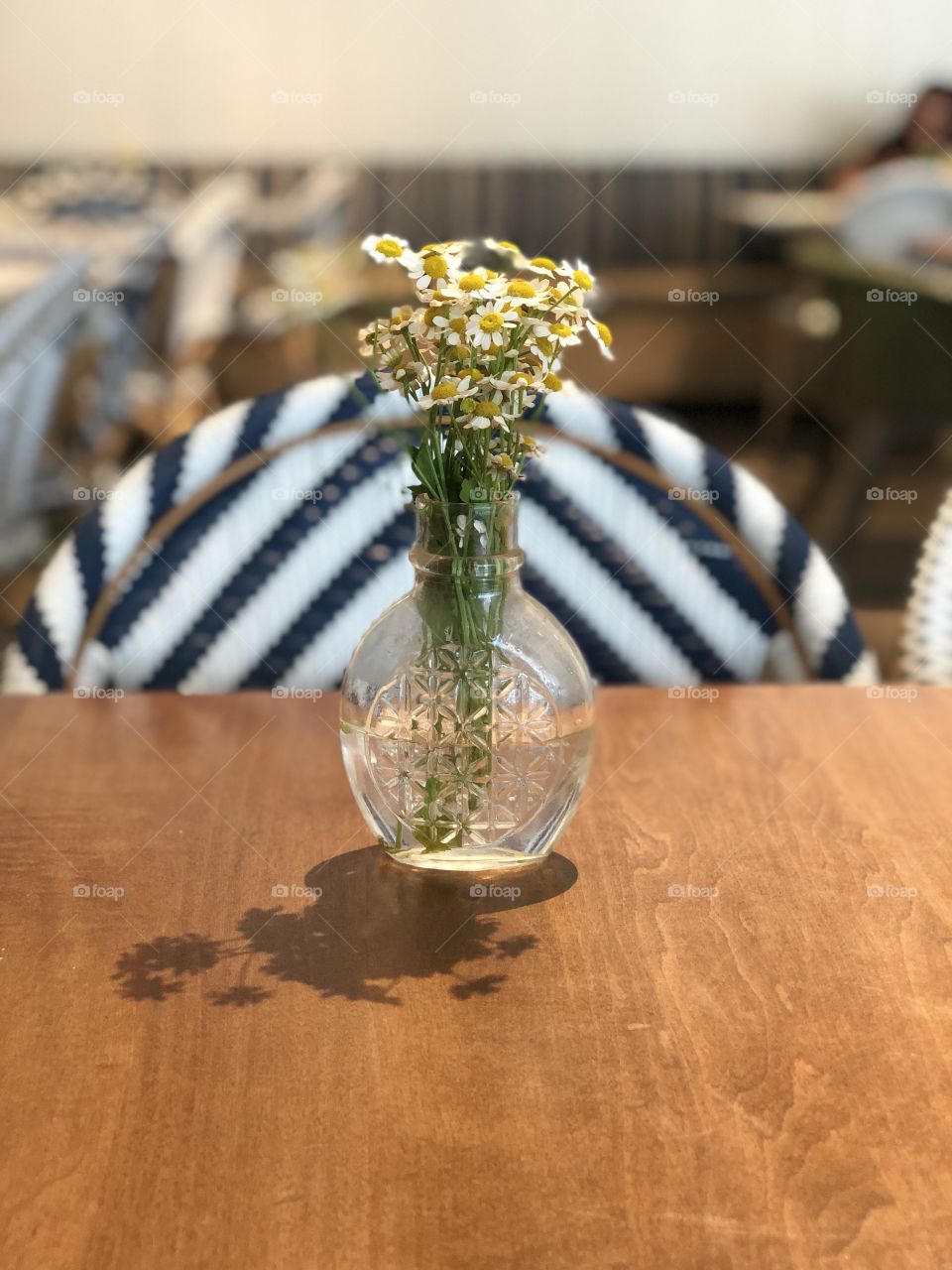 Centerpiece decoration. White flowers with a clear vase. Wooden table. 