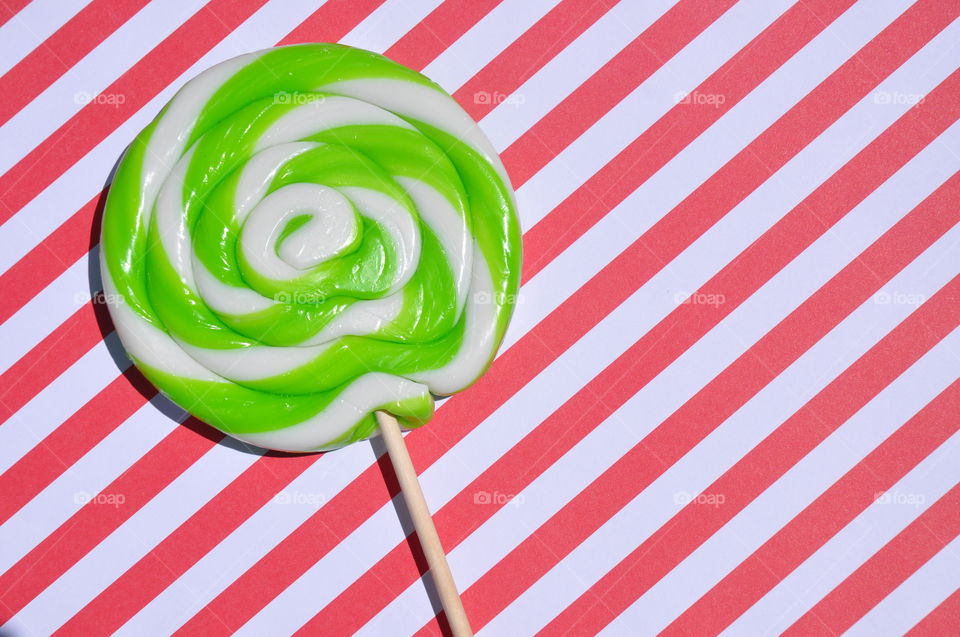 Large lollipop against a striped background. 