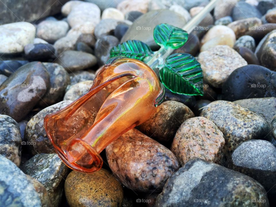 Glass rose on river rock. 