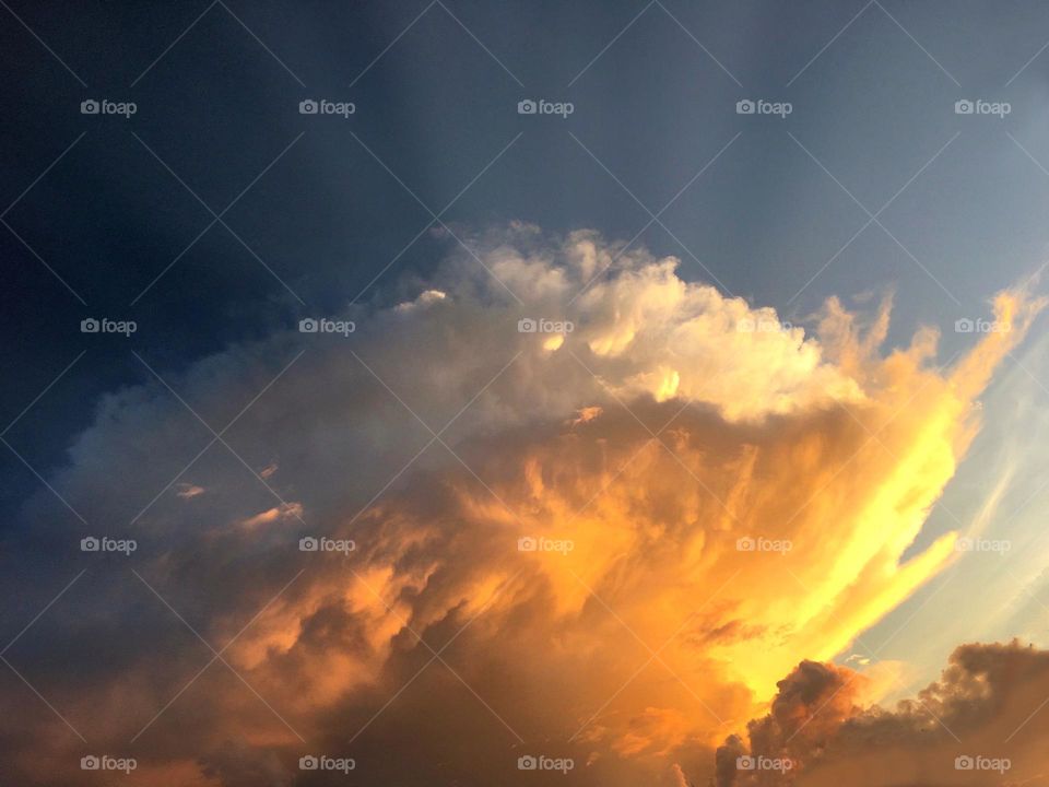 Gorgeous towering white and orange clouds at sunset.