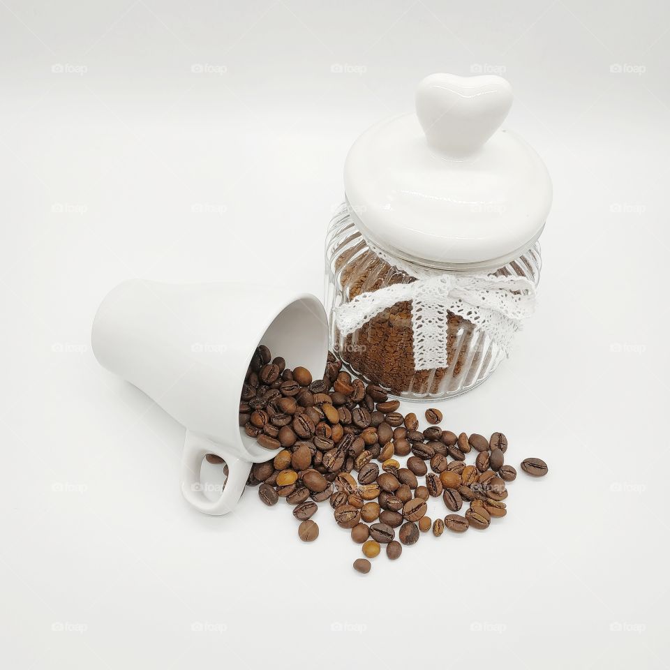 jar filled with coffee and roasted coffee beans on white background, waking up from mugs