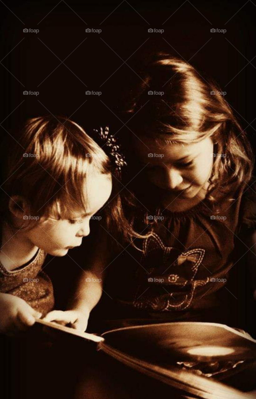 Sisters reading a book