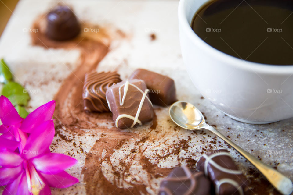 Chocolate coffee and cocoa with a cup of coffee and single spoon and a pink flower. Sugar sweet and delicious