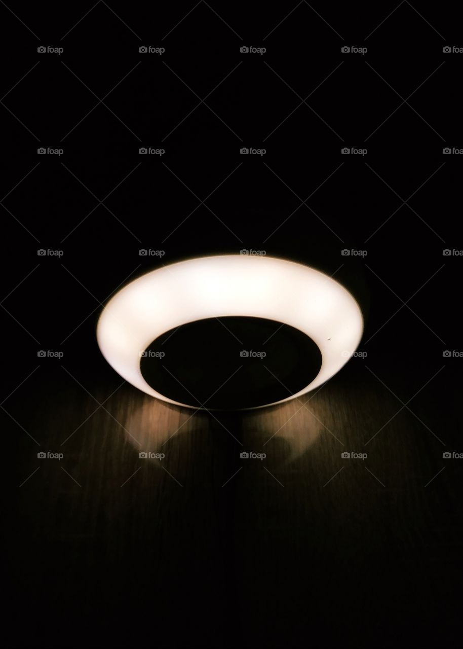 An artificially white lights iluminated radio station with its reflection on the table. In the dark room.