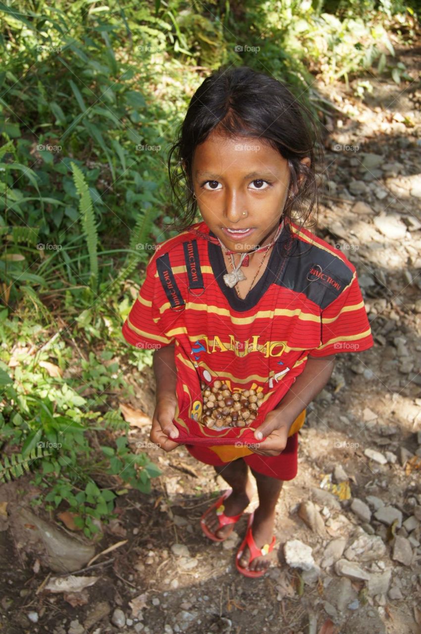 Girl with her Chestnuts . While trekking in Nepal , I crossed path with this little girl and showed me some of her chestnuts that she just picked 