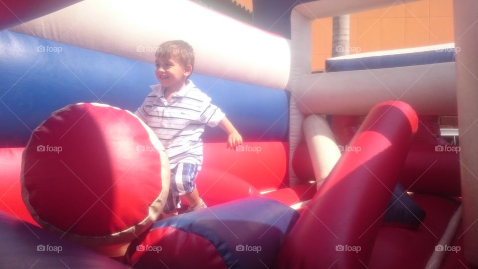 boy at playground. preschooler having fun at bouncy house