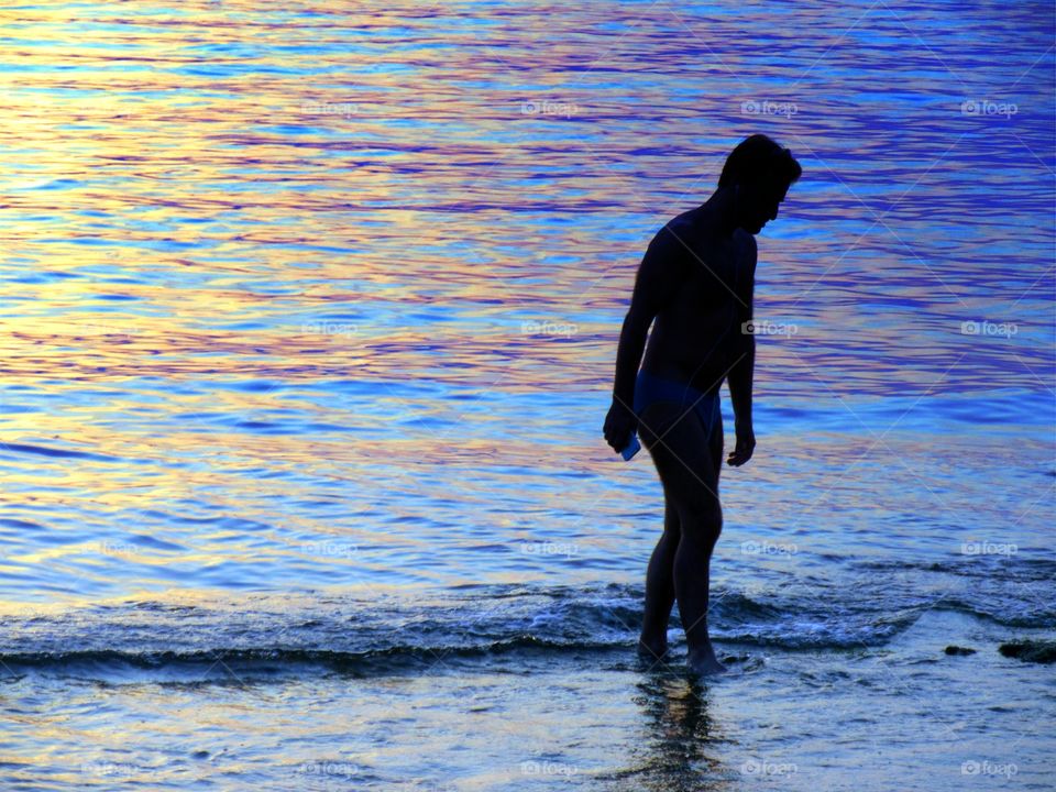 Sea at sunset with a people silhouette.