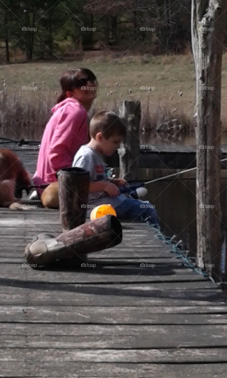Mother with her son fishing at lake side