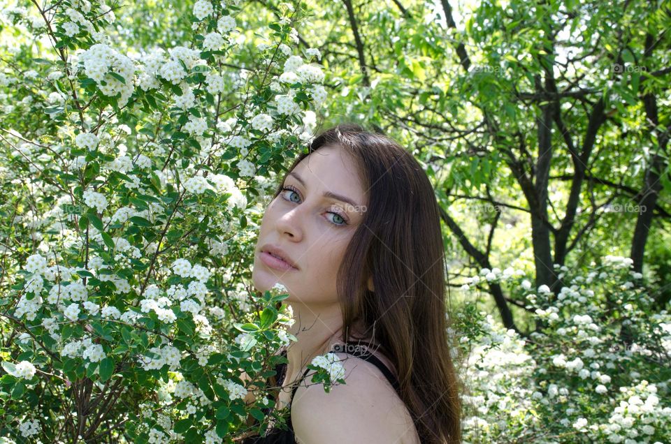 Portrait of a Beautiful Young Girl on Background of Flowers