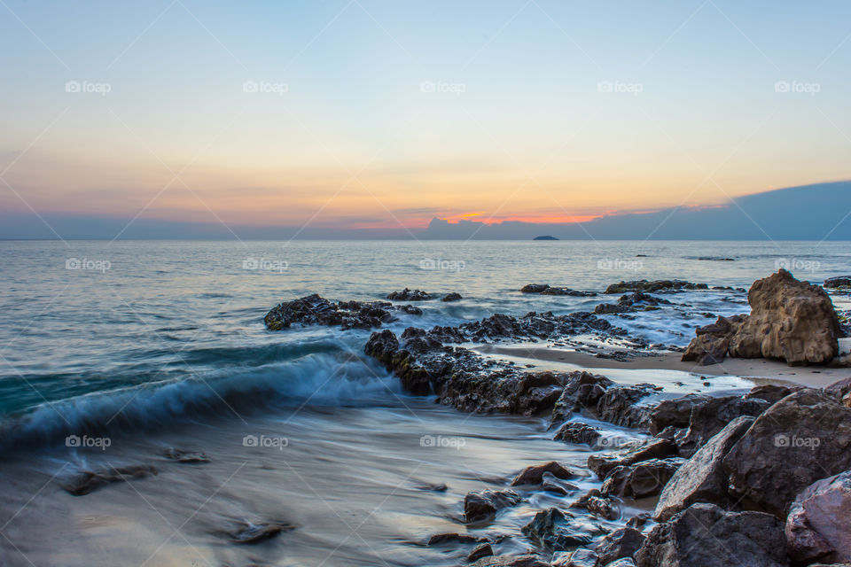 Scenic view of dramatic sky at rocky beach