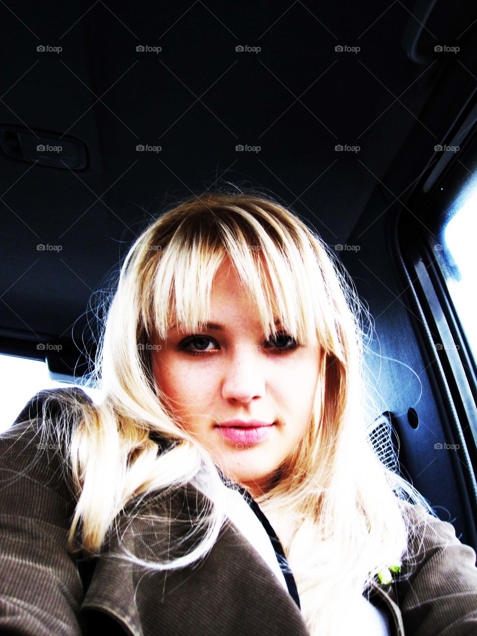Beautiful blonde girl sitting in car