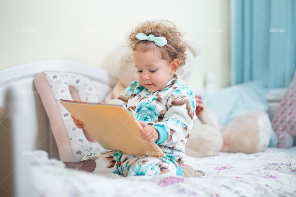 Cute little girl reading a book