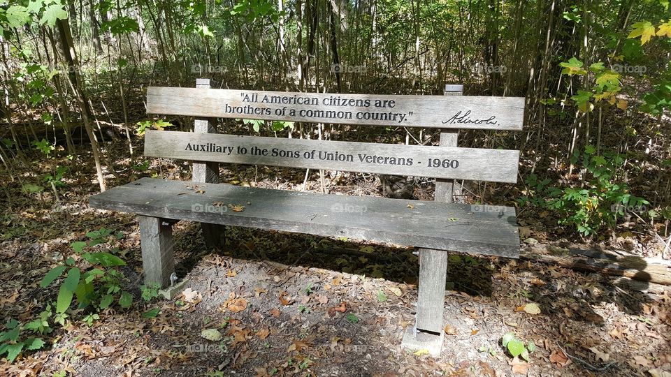 an aging bench with an inscription of one of Lincoln's famous quotes, at the Abraham Lincoln Memorial Gardens