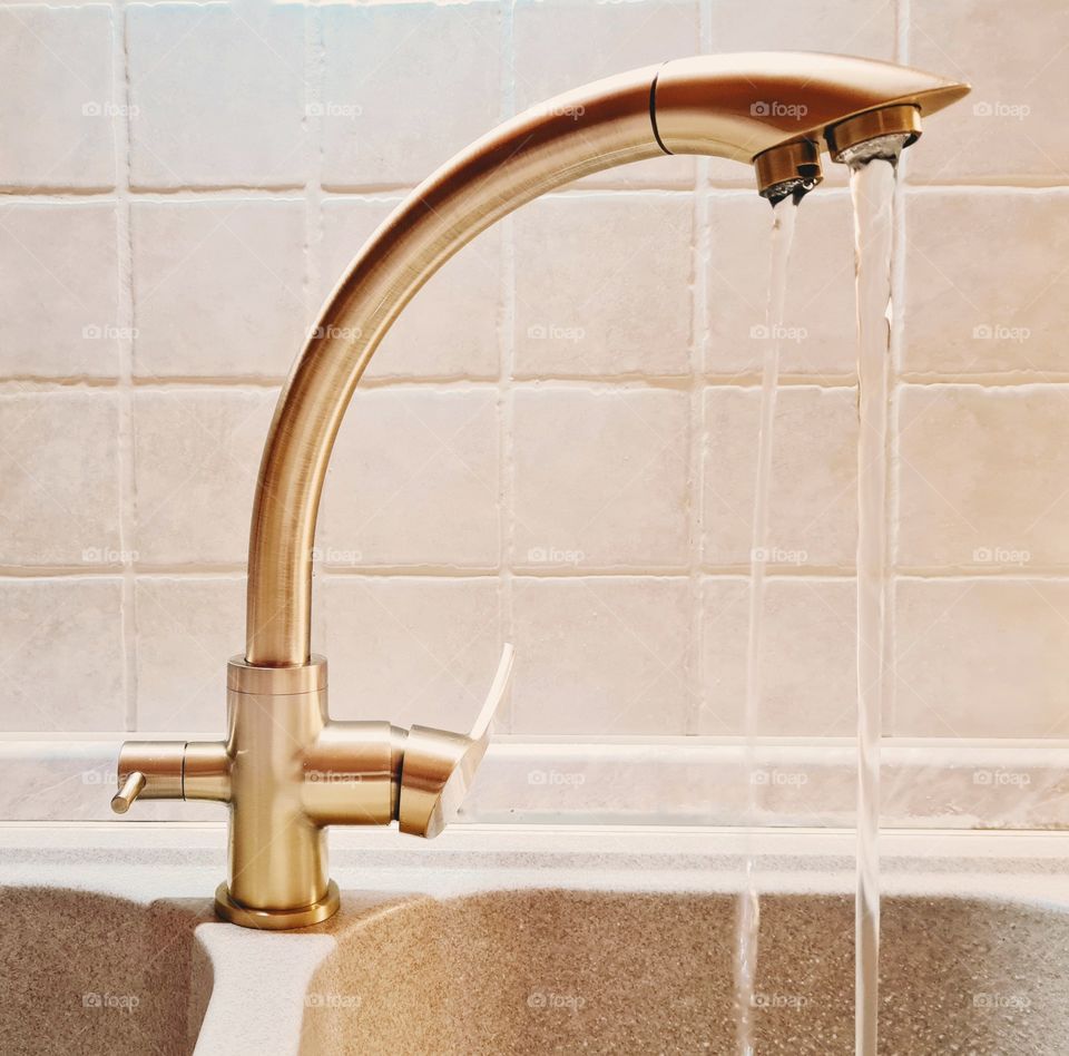 three-way bronze colored faucet connected to a purifier