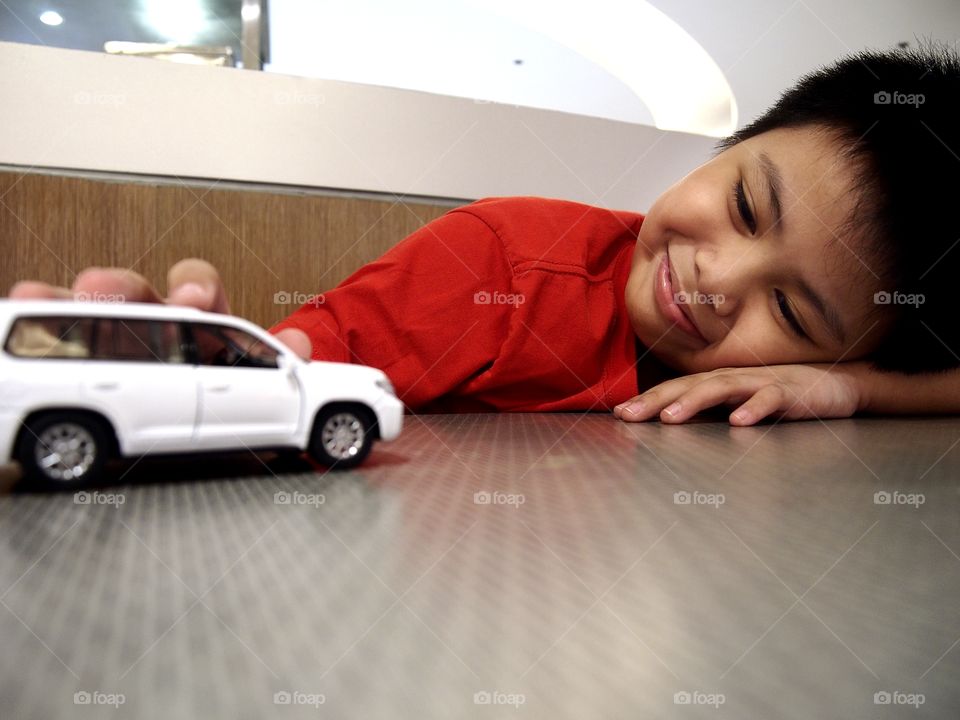 young boy playing with a toy car