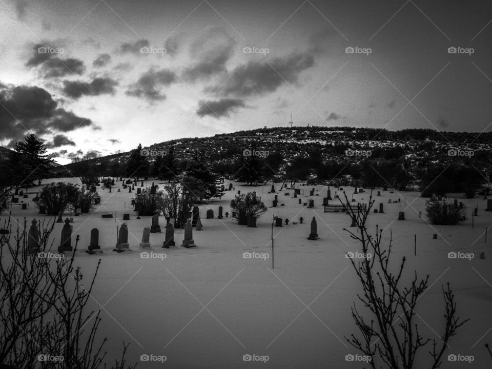 Black and white photo ominous cemetery in winter Mountainside