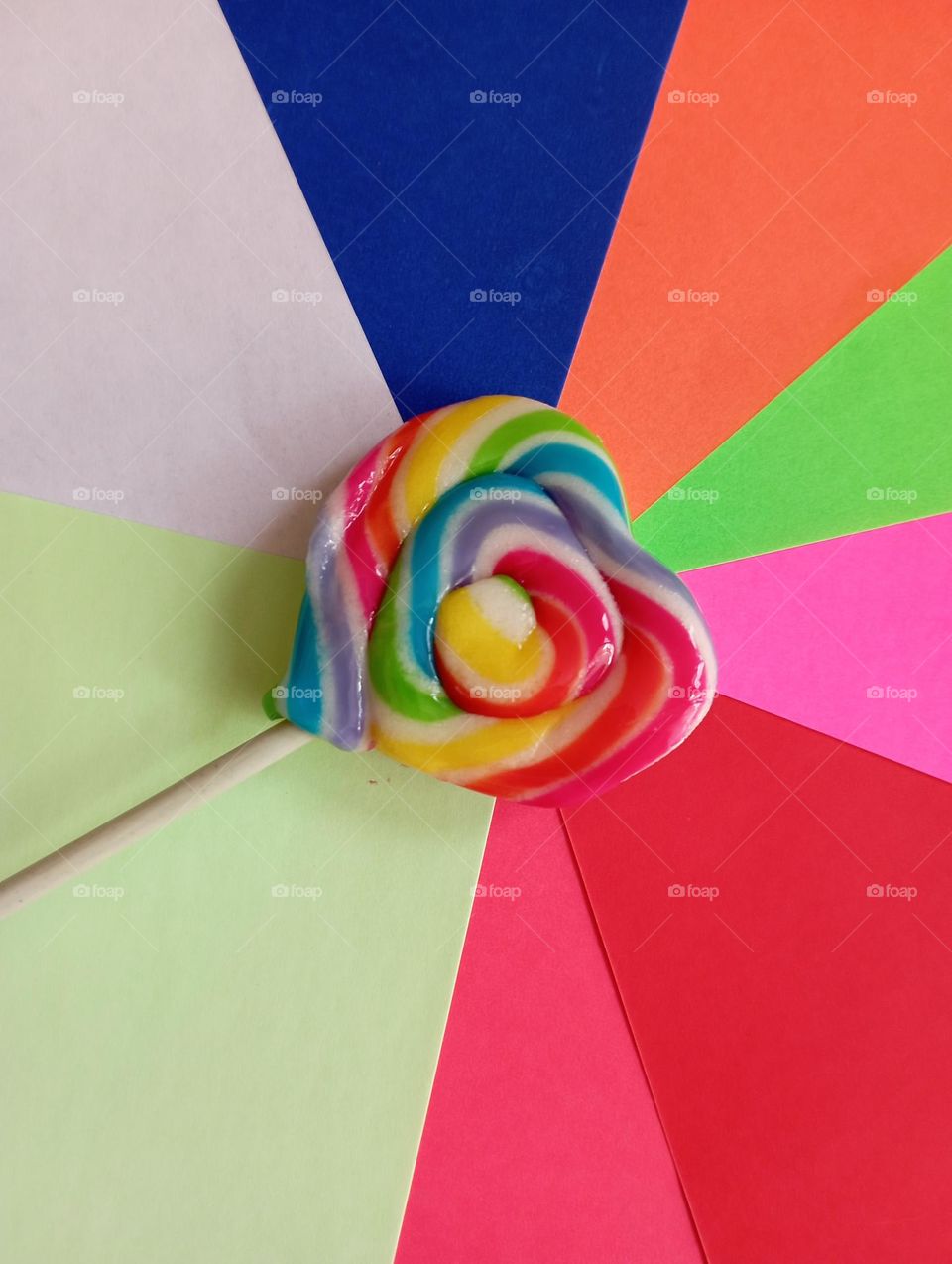 Rainbow candy against origami paper as background