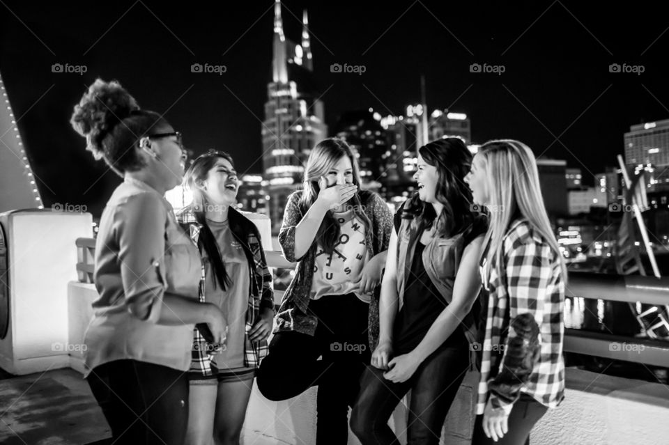 Girls on a bridge overlooking downtown Nashville at night