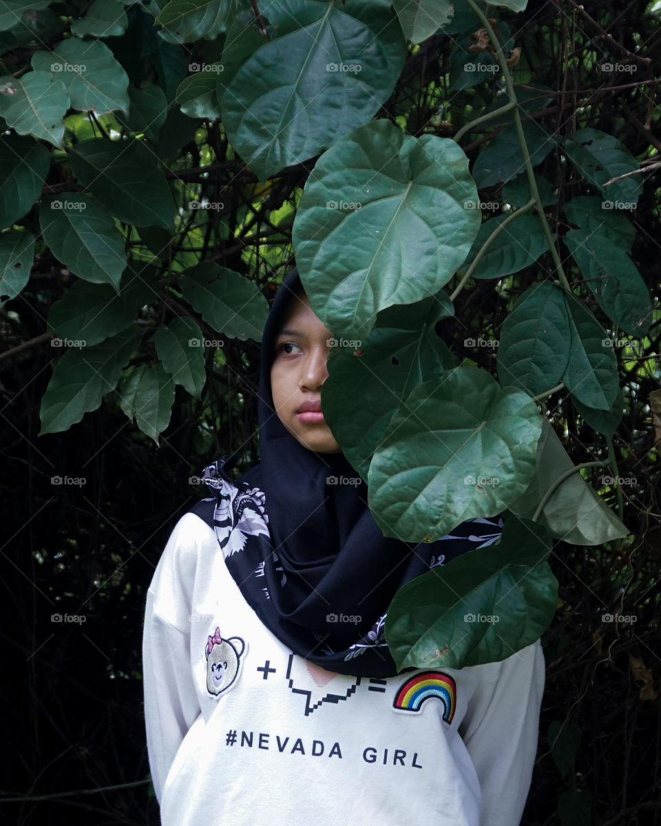 A girl is hiding in leaf.