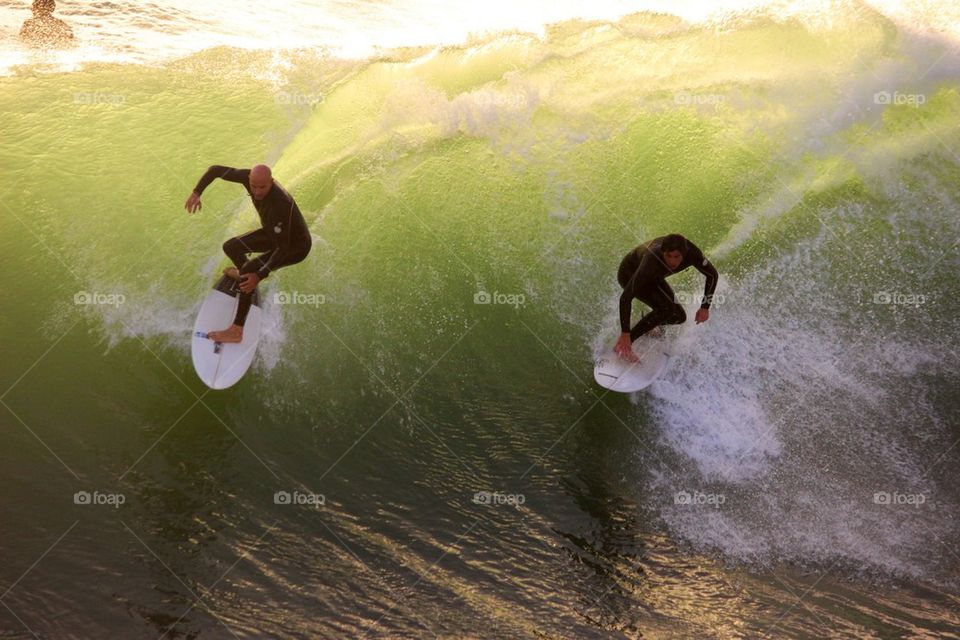 Surfers sharing a wave