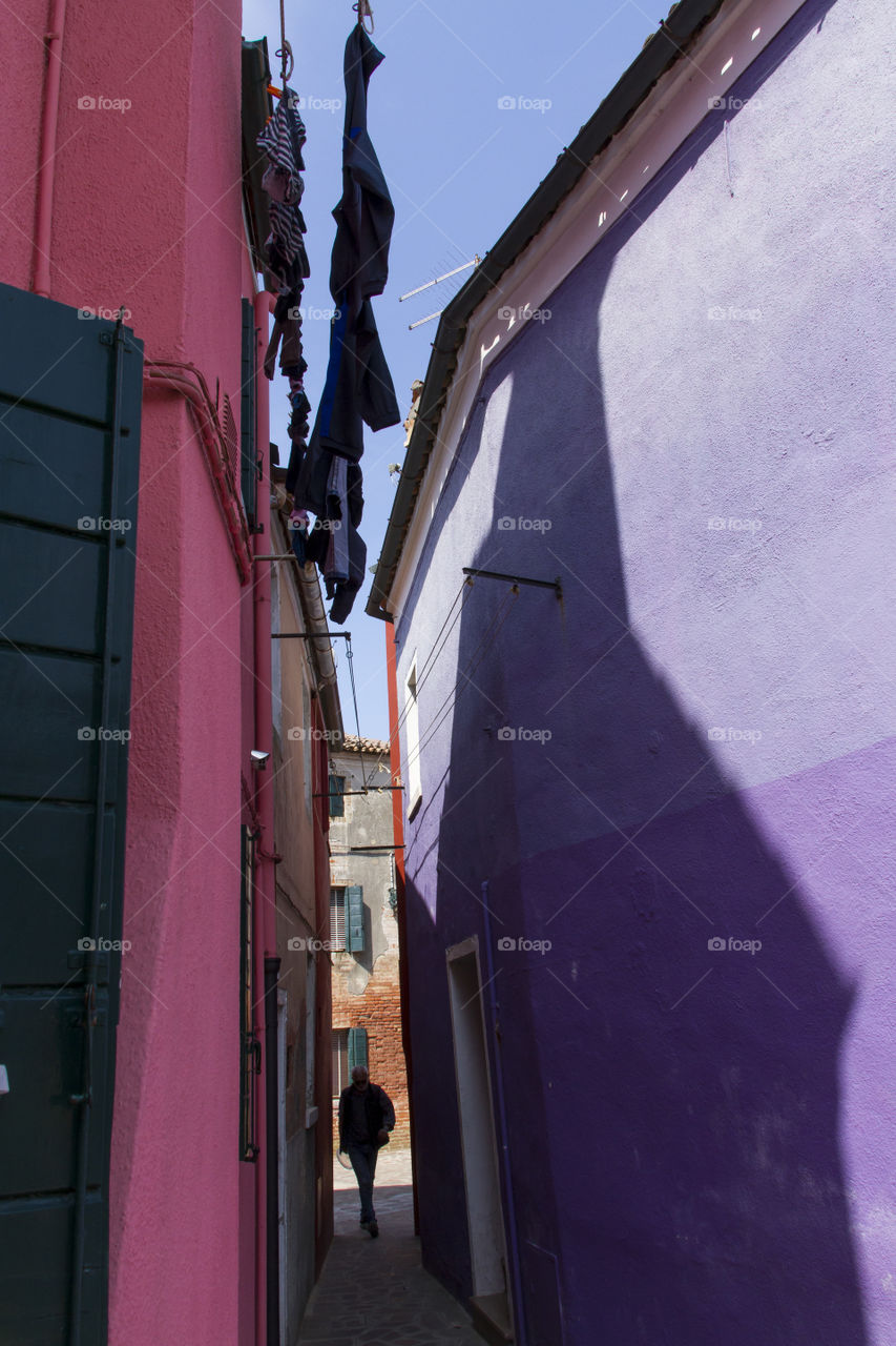 Narrow walkway between colorful houses of Burano. 