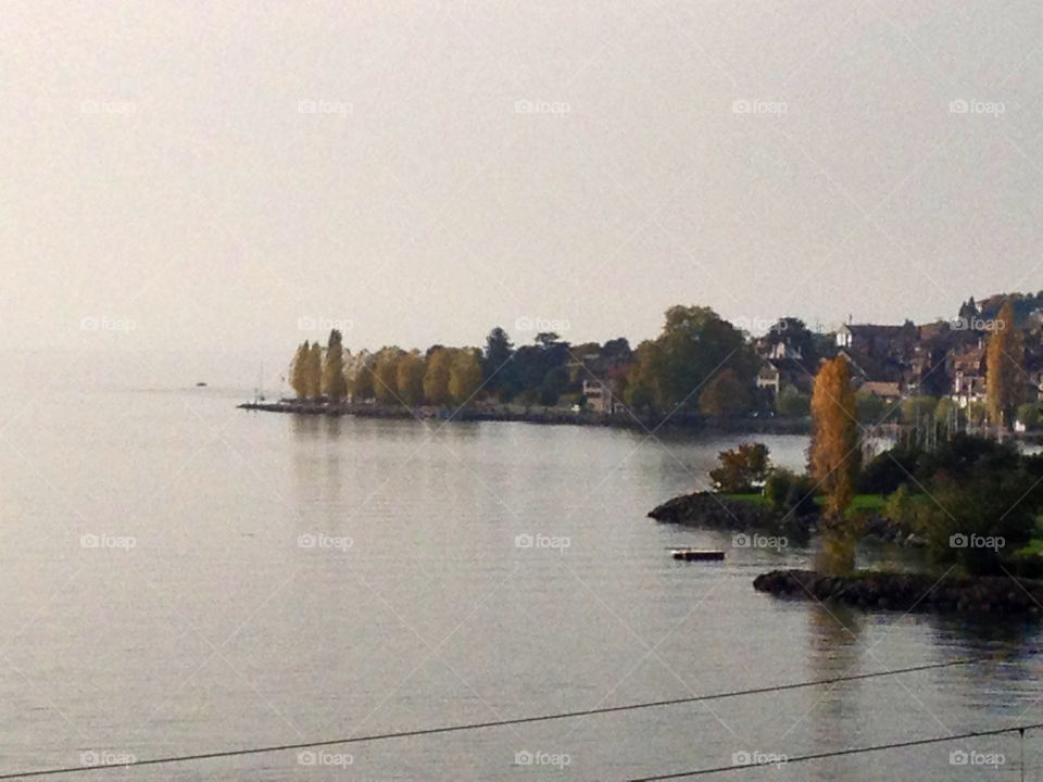 cully quiet lake of geneva before strong storm and colour trees by swisstraveler