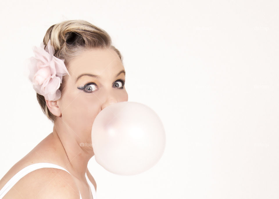 Attractive woman blowing bubble gum