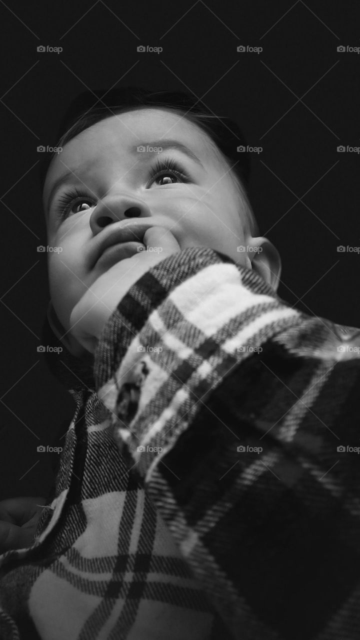 black and white photo of a baby looking thoughtfully