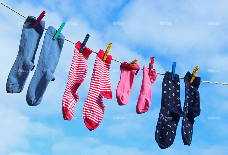 Colorful sock on clothesline against sky