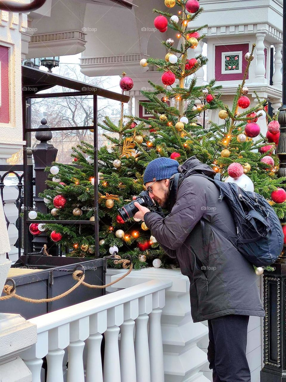 A man stands on the New Year's street and takes pictures with a camera