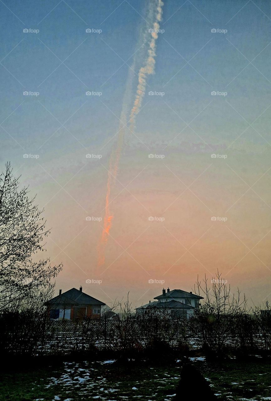 vertical airplane condensation plume at dawn