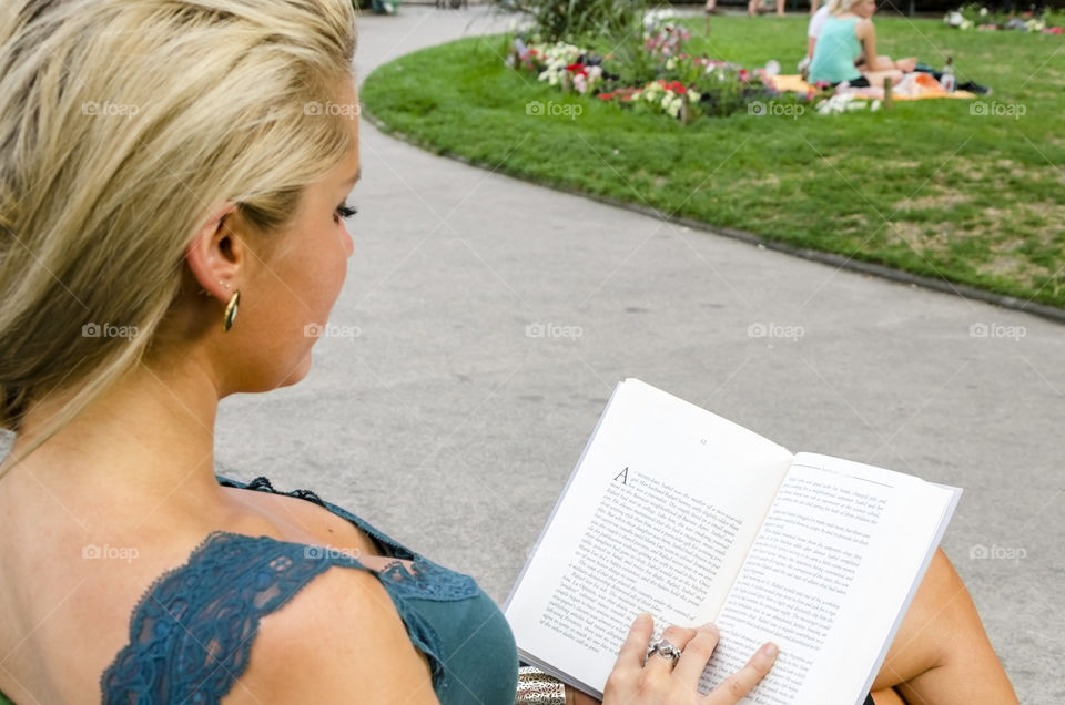 Reading in a park. Woman reading a book in a park 
