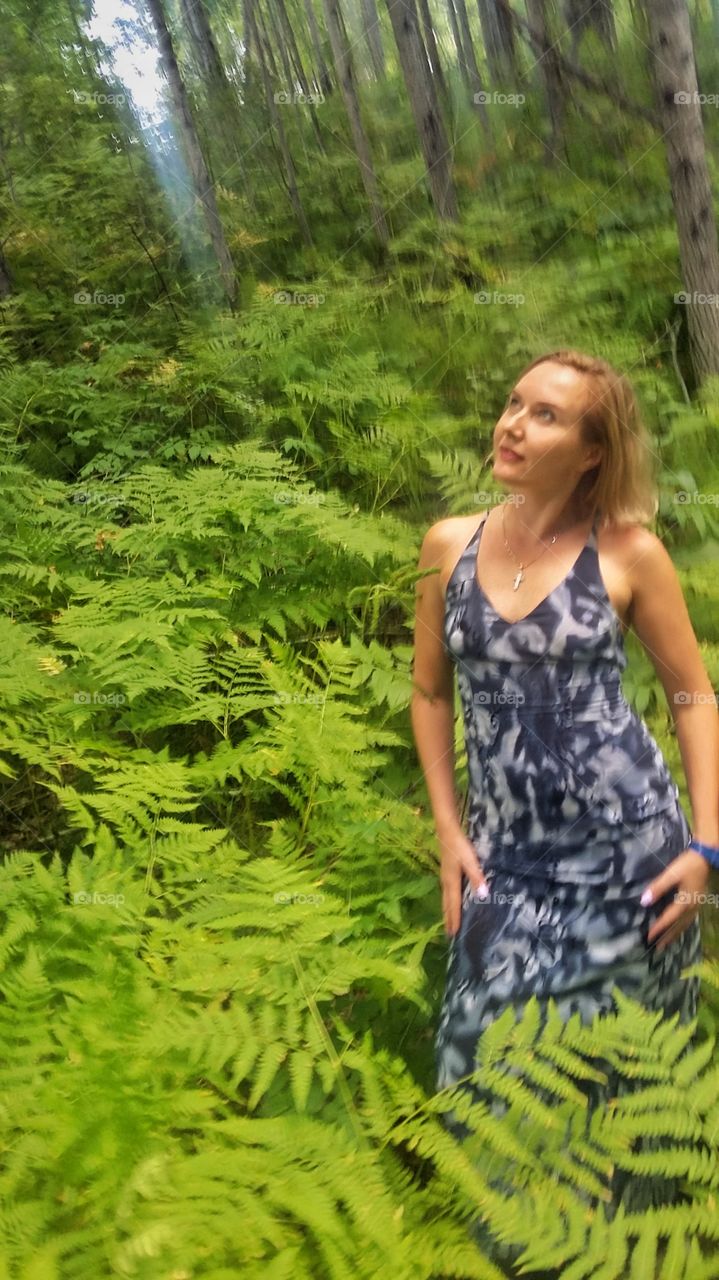 девушка в лесу на фоне зеленого папоротника