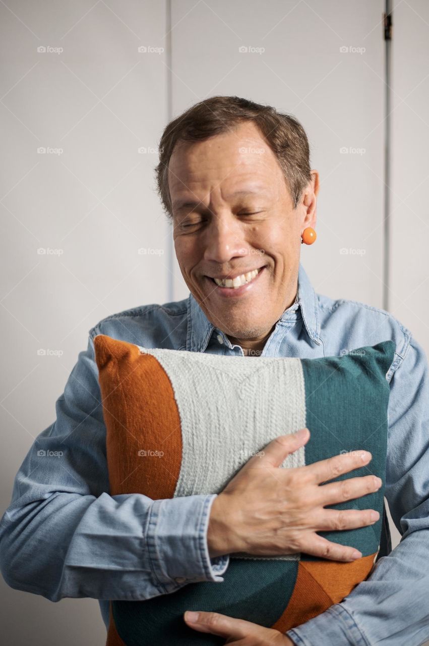 Portrait of a man holding a pillow 