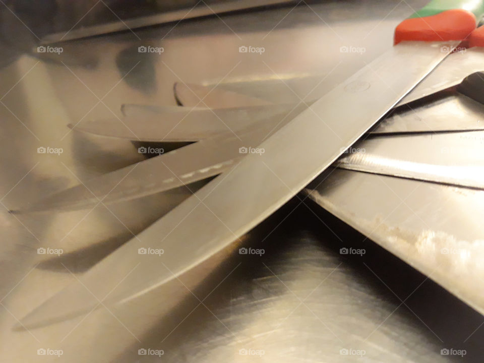 Five knifes on circle in clean metal in a restaurant's kitchen. clean and ordered cooking professional instrument