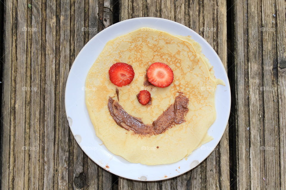 Smiley pancake with strawberry slices 