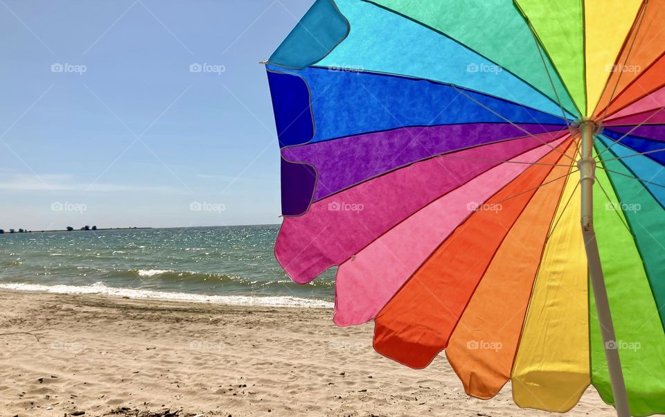 Rainbow umbrella on the beach.