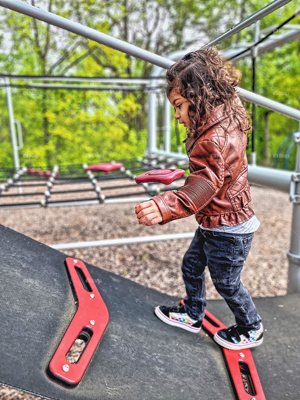 Toddler girl climbing on playground equipment at the park, toddler explores the park, toddler girl loves climbing, toddler has no fear 