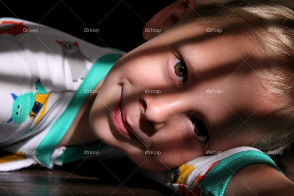 Cute boy lying on hardwood floor