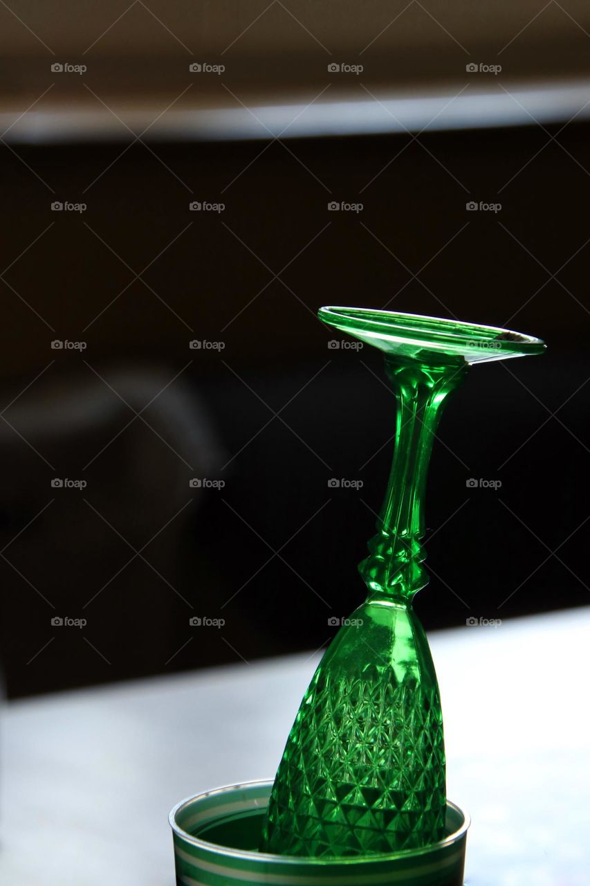 Close-up of a green champagne glass upside down in a mug