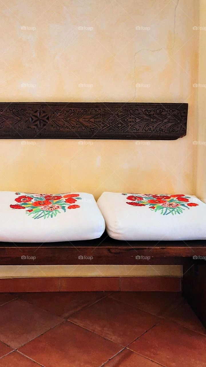 Wooden bench with beautiful embroidered pillows.. The colors of autumn