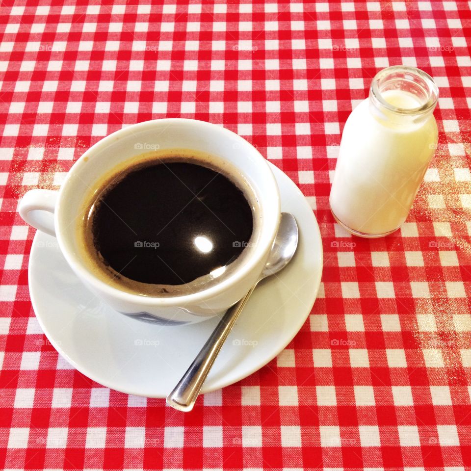 Cup of coffee. Cup of coffee on a red gingham tablecloth