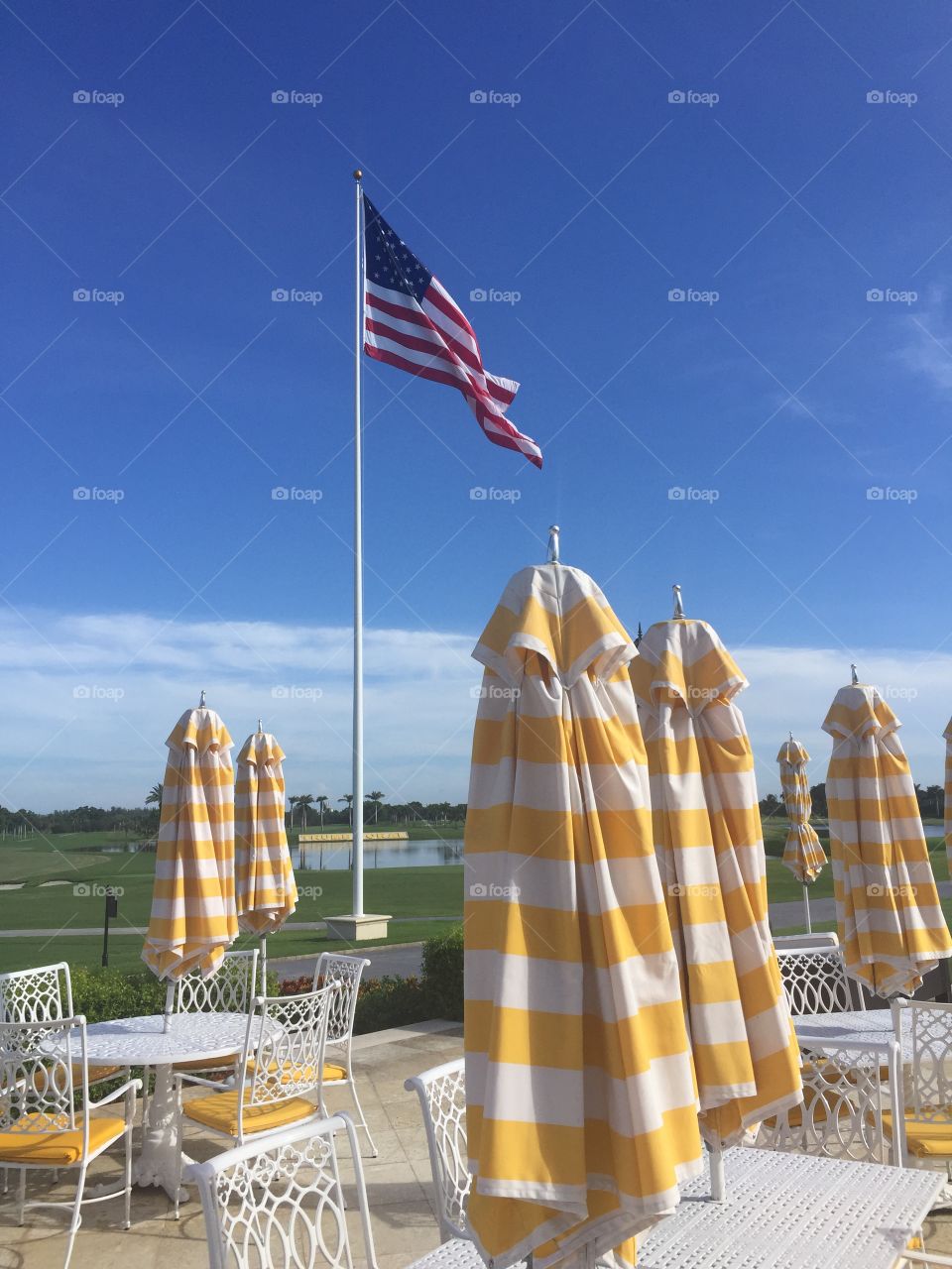 Trump Hotel at Doral. Closed umbrellas with tables at resort 