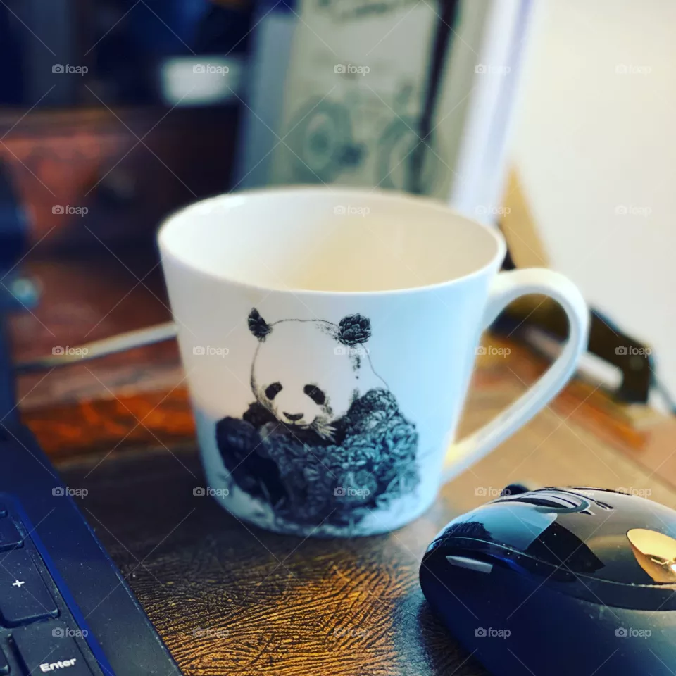 Half full cup of coffee on an old style working desk in home office