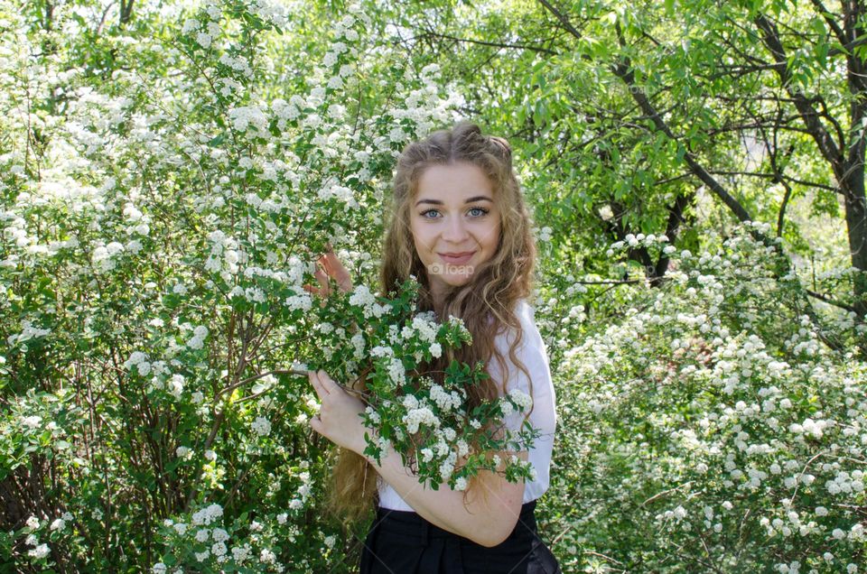 Portrait of Beautiful Young Girl on Flowers Background