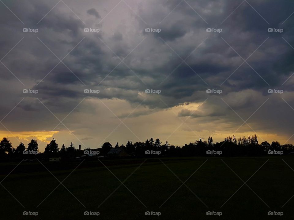 A sunrise / sunset with churning clouds with wind coming up with rain