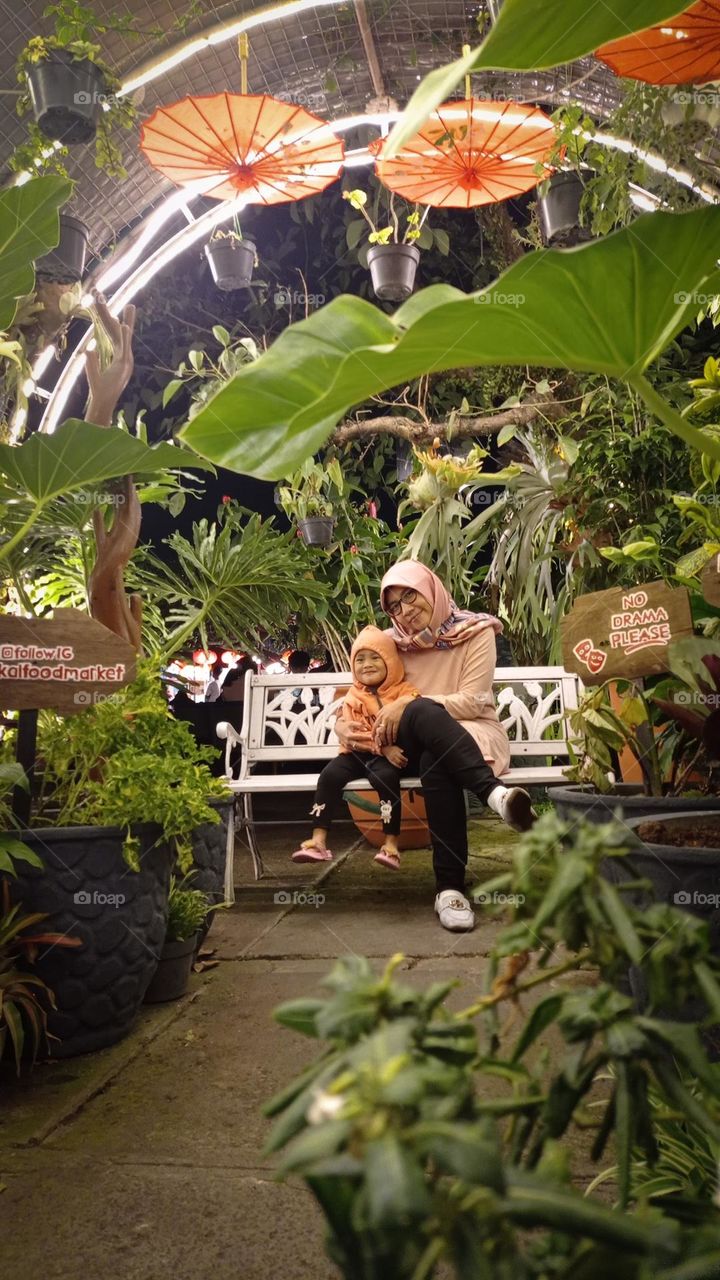 mother and her daughter in the middle of the garden.